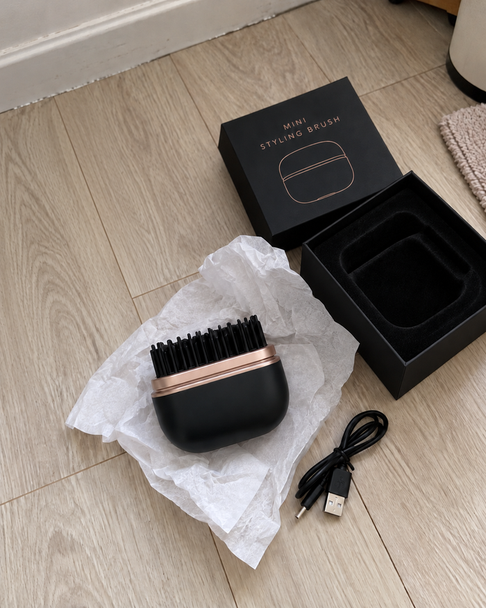 Michi's black mini styling brush with USB charging cable and opened black packaging